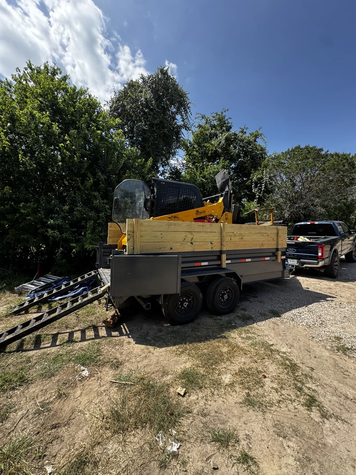 CAT skid steer loaded in 14-foot dump trailer